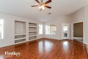 Mesa house for rent - an empty living room with wood floors and a ceiling fan
