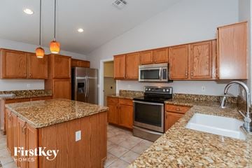 Mesa house for rent - a kitchen with granite counter tops and wooden cabinets