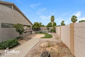 Mesa house for rent - a backyard with a pool and palm trees
