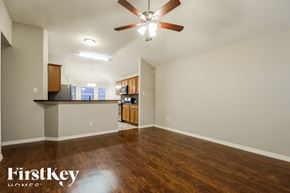 Conroe house for rent - A spacious room with a ceiling fan and wooden flooring.