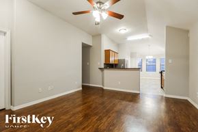Conroe house for rent - A spacious room with wooden floors and a ceiling fan.