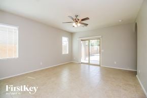San Tan Valley house for rent - an empty living room with a ceiling fan and a door to a patio