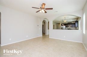 San Tan Valley house for rent - an empty living room with a ceiling fan and a kitchen