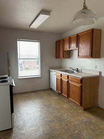 Killeen apartment for rent - an empty kitchen with wooden cabinets and a sink