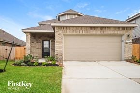 New Caney house for rent - A house with a garage door that says FirstKey Homes.