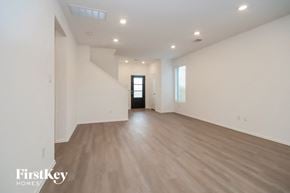 New Caney house for rent - A spacious room with wooden flooring and a door at the end.