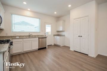 New Caney house for rent - A kitchen with a stove top oven and a window with blinds.