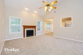 Clarksville house for rent - A spacious living room with a fireplace and a ceiling fan.