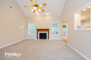 Clarksville house for rent - A spacious living room with a fireplace and a ceiling fan.