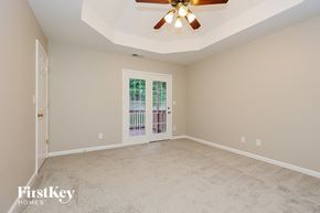 Clarksville house for rent - A spacious room with a ceiling fan and a door leading to a balcony.