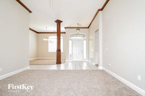 Edmond house for rent - an empty living room with carpet and a white door