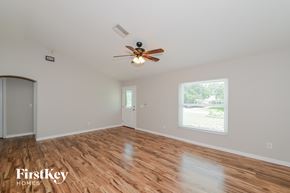 North Port house for rent - A room with a ceiling fan and wooden flooring.