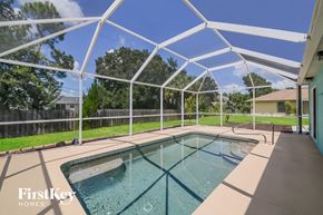 North Port house for rent - A pool under a white canopy with the words "FirstKey Homes" on the bottom left.