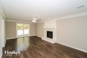 Memphis house for rent - A spacious living room with a fireplace and a ceiling fan.