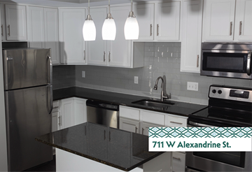 Detroit apartment for rent - A kitchen with a black counter top and white cabinets.