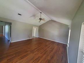 Deridder house for rent - A room with wooden floors and a ceiling fan.