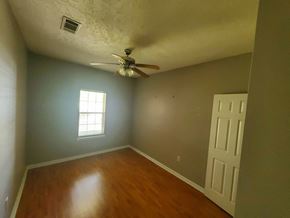 Deridder house for rent - A room with a ceiling fan and a door.