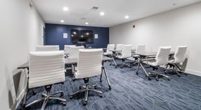 Landover apartment for rent - A conference room with white chairs and a blue carpet.