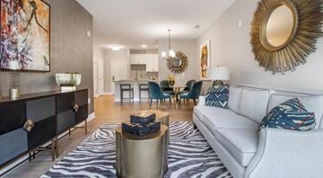 Landover apartment for rent - A living room with a white couch and a zebra print rug.