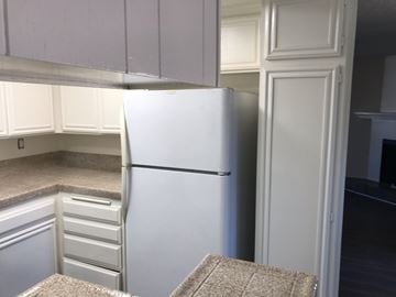 Long Beach apartment for rent - A white refrigerator in a kitchen with white cabinets.
