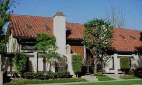 Long Beach apartment for rent - A house with a red tile roof and a white fence.