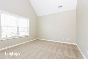 Clarksville house for rent - a bedroom with a large window and a carpeted floor