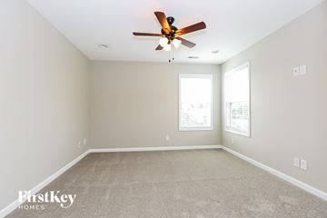 Clarksville house for rent - a spacious living room with carpet and a ceiling fan