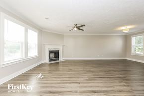 Thompsons Station house for rent - A spacious room with a fireplace and a ceiling fan.