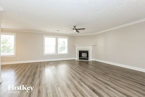 Thompsons Station house for rent - A spacious room with a fireplace and a ceiling fan.