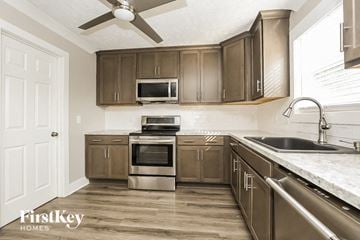 Thompsons Station house for rent - A kitchen with brown cabinets and a stainless steel oven.