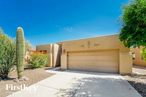 Tucson house for rent - A house with a garage door and a cactus in front.