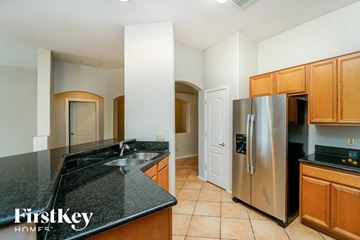 Tucson house for rent - A kitchen with a black granite counter top and wooden cabinets.