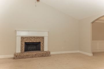 Statham house for rent - a living room with a fireplace and a carpet