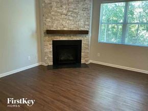 Dallas house for rent - a living room with a hard wood floor and a stone fireplace