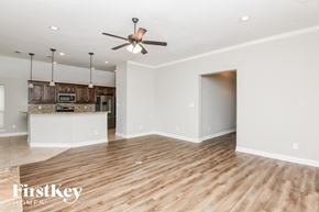 Weatherford house for rent - an empty living room and kitchen with a ceiling fan