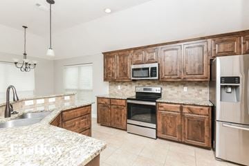 Weatherford house for rent - a kitchen with wooden cabinets and stainless steel appliances