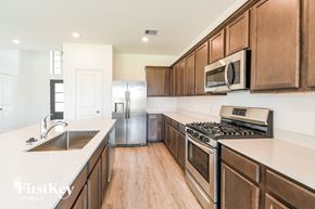 La Marque house for rent - a kitchen with wooden cabinets and stainless steel appliances