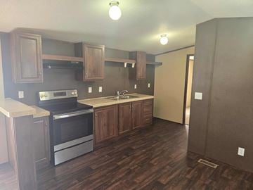 Shawnee house for rent - A kitchen with wooden cabinets and a stainless steel oven.