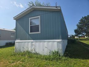 Shawnee house for rent - A blue house with a white window and a white garage door.