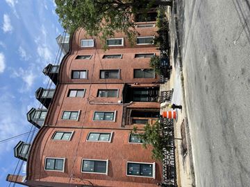 East Boston apartment for rent - a tall brick building with trees on top of it