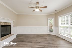 Huntersville house for rent - a empty living room with a ceiling fan and a fireplace