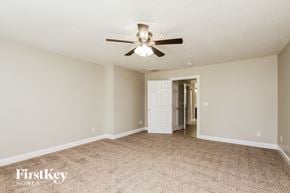 Huntersville house for rent - a living room with a ceiling fan and a door to a hallway
