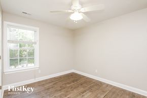 Huntersville house for rent - an empty bedroom with a ceiling fan and a window
