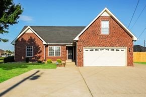 Smyrna house for rent - a red brick house with a white garage door