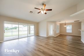 Cape Coral house for rent - an empty living room with wood floors and a ceiling fan