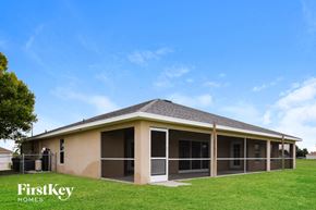 Cape Coral house for rent - a manufactured home with a porch and a grass yard