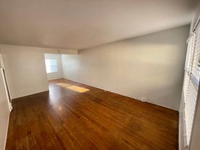 Long Beach apartment for rent - A room with wooden floors and white walls.