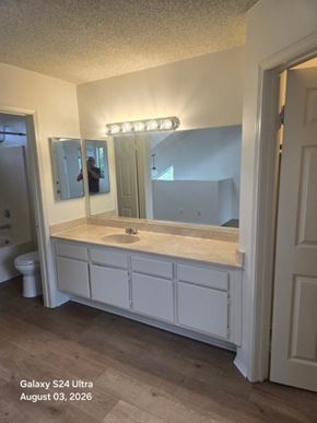 Long Beach apartment for rent - A bathroom with a white vanity and a mirror with lights above it.