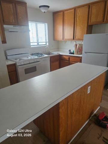 Long Beach apartment for rent - A kitchen with wooden cabinets and a white island.