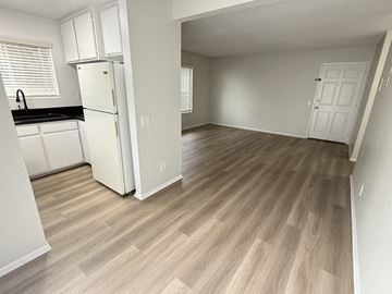 Long Beach apartment for rent - A kitchen with white cabinets and a fridge is shown.